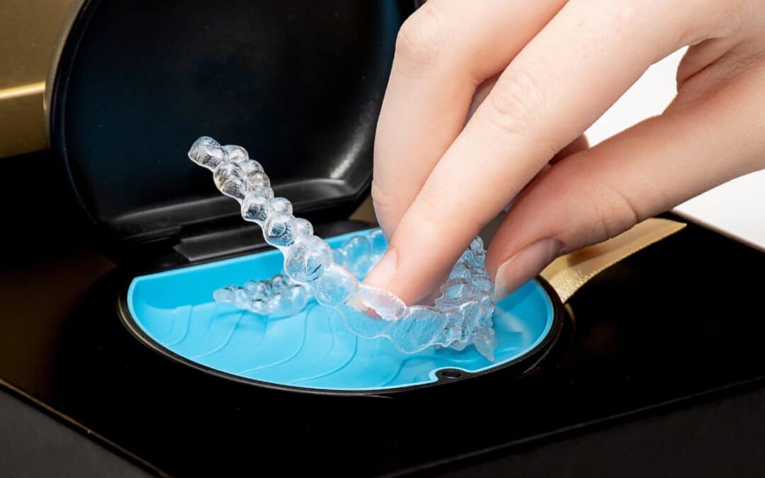 Hand holding clear aligner tray