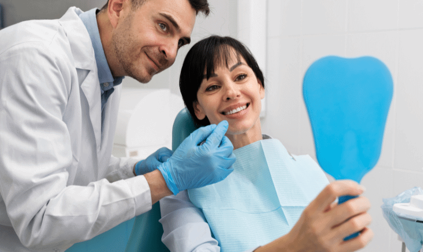 Dentist and patient smiling together