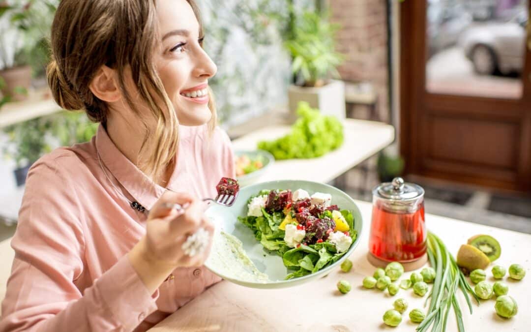 Woman eating salad outdoors smiling