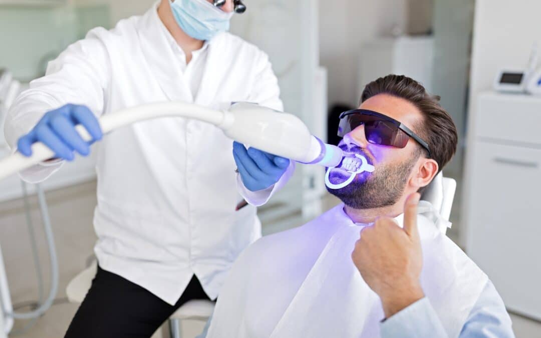 Dentist applying whitening treatment with blue light