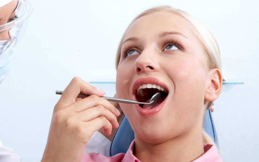 Woman having dental exam with mirror tool