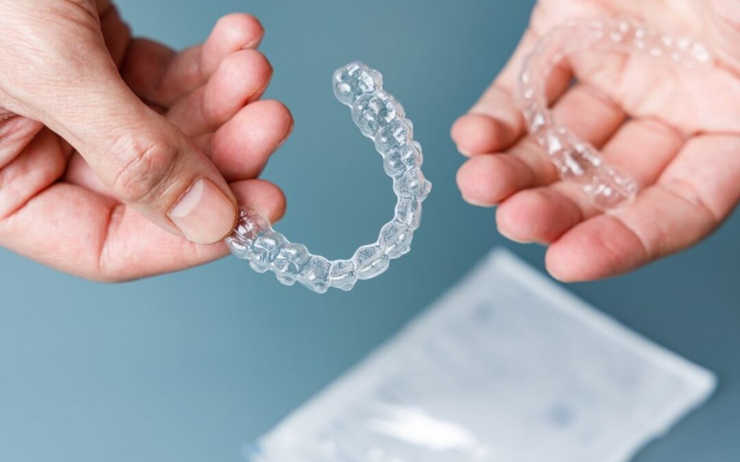 Hand holding invisalign clear aligner