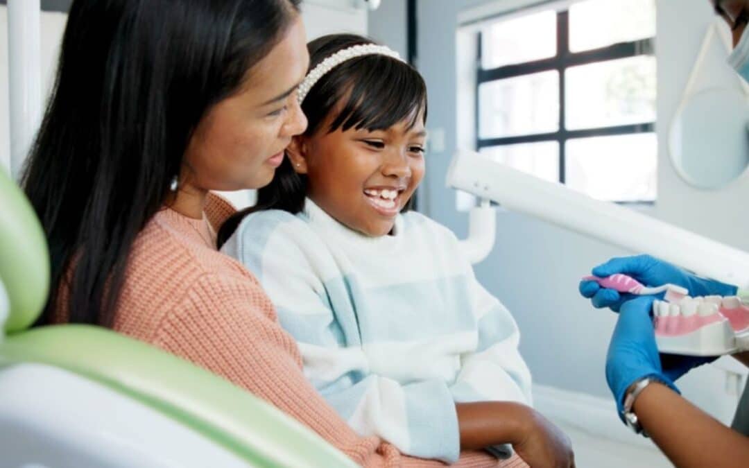 Mother and daughter smiling together at dental office